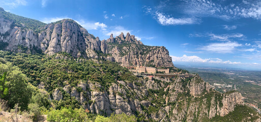 A mountain range with a clear blue sky and a few clouds