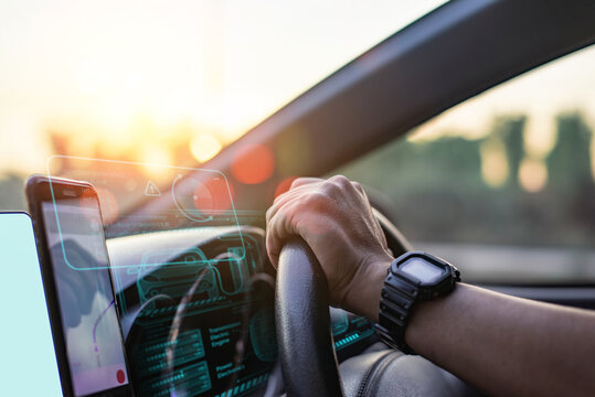 Close-up of a driver's hand on the steering wheel, with futuristic digital dashboard and navigation display at sunset. - Powered by Adobe