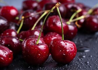 Fresh red cherries fruit. Fresh organic berries with leaves macro. Large collection of fresh red cherries. Ripe cherries background. Lot of red ripe cherries close up with water drops.