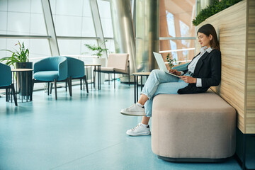 Young girl works on outsourcing while sitting in coworking space