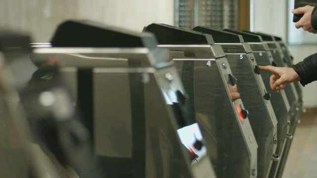 Passengers pass through the turnstile. People pay the fare. Passengers throw token of admission. Public transport. Infrastructure.