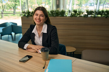 Woman sitting at the table and looking at the camera