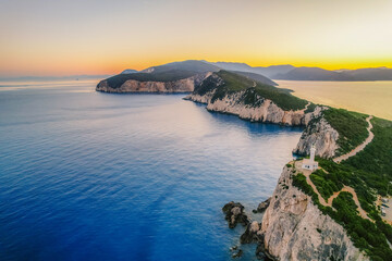 Lighthouse on the cliff. Seascape of Cape Lefkatas with old lighthouse on Lefkada island, Greece. Beautiful views of azure sea water and nature with cliffs