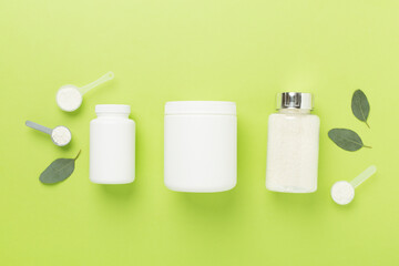 Jars with protein powder on color background, top view. Sports nutrition concept