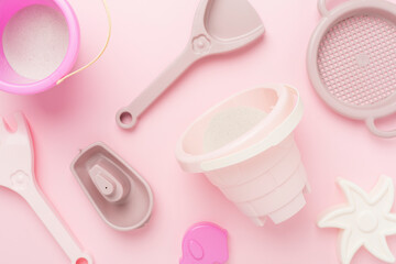 Cute toys for playing with sand on color background, top view