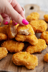 A woman's hand takes Chicken Nugget, side view. Close-up.