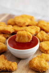 Crunchy Chicken Nuggets with Ketchup on a wooden board, side view. Close-up.