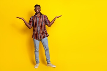 Full body portrait of nice young man hold empty space wear shirt isolated on yellow color background