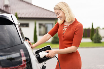 Woman Charging Electric Car At Home, Eco-Friendly Transportation, Sustainable Lifestyle