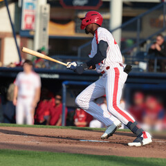 baseball player swinging his bat and running