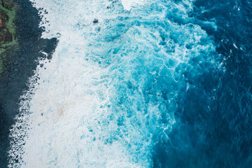 Aerial view of rough ocean with waves and volcanic beach, porto Moniz Madeira, Portugal