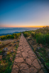 Hiking on the highest peak of Madeira Pico Ruivo next to the cottage Abrigo do Pico Ruivo. Views of the surrounding mountains lanscape during sunrise