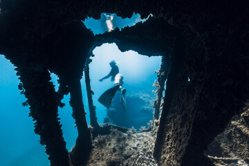 Freediver underwater among the ruins of a ship. Freediving in wreck ship