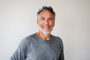 Obraz premium Portrait of a cheerful caucasian man in his 50s sporting a long-sleeved thermal undershirt in front of white background