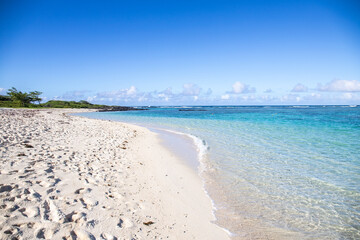 Fantastic sandy beach in the morning. An island in the Indian Ocean, landscape photo or seascape with the sun rising over the sea. There are small lava rocks on the beach 
Trou d'Eau Douce, Mauritius
