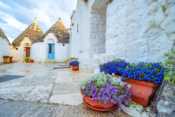 Trulli of Alberobello, Puglia, Italy. town of Alberobello with trulli houses among green plants and...