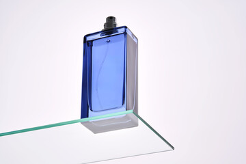 Perfume spray in a blue bottle on a white background.