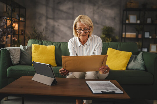 Mature woman work from home open with good news letter post envelope - Powered by Adobe
