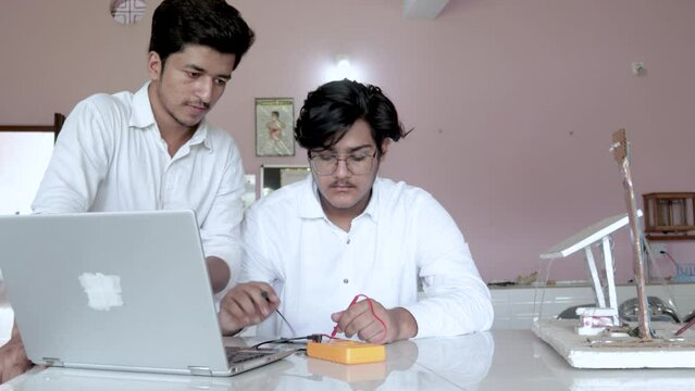 Dolly IN shot of Students working and testing the equipment, Student working on Pcb board in Lab for project in Electronic Engineering	
