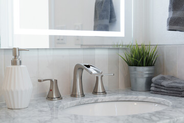 modern bathroom sink with marble countertop, faucet, and mirror