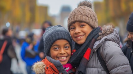 Two children refugees smiling warmly, dressed in winter hats and jackets, enjoying time outdoors in the city.