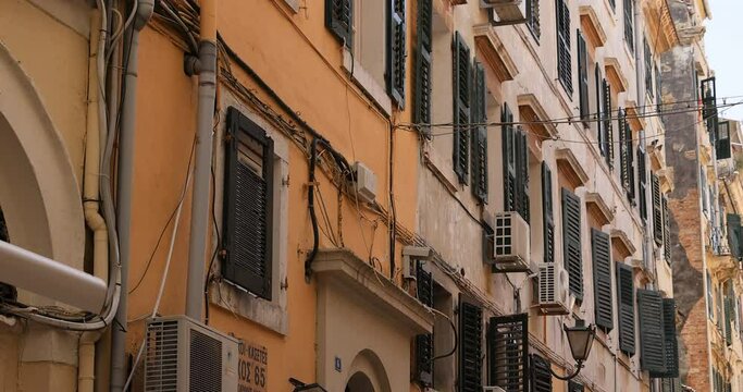 Corfu Greece narrow street historical building homes pan. Greek island in the Ionian Sea of Greece. Beginnings of Greek mythology. Mediterranean climate. Historical Urban architecture.