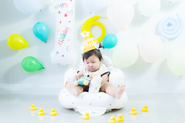 A young girl celebrates her 1st birthday. A young Asian girl celebrates her first birthday.