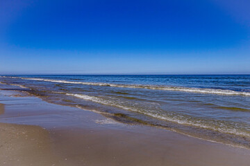 Kleine Wellen der Nordsee. Der Sandstrand von Ameland im Sommer.