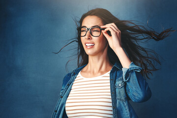 Girl, surprise and glasses with wind in studio for hair blow, crazy weather and comedy for good...