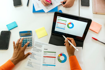 Business people analyzing financial data on tablet and documents