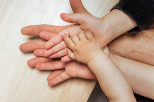 Hands of different generations in a family moment