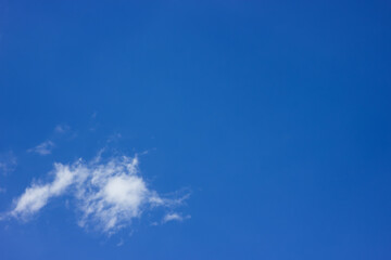 small white cloud in front of blue sky suitable as background or wallpaper with lots of copy space