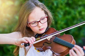 Child, playing and violin for instrument outdoor as youth musician, creative learning and string...