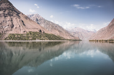 Blue mirror water of Panj river between Afghanistan and Tajikistan, river flows in a valley among...