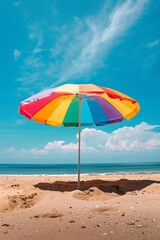 Colorful beach umbrella set against a clear blue sky and sandy beach background