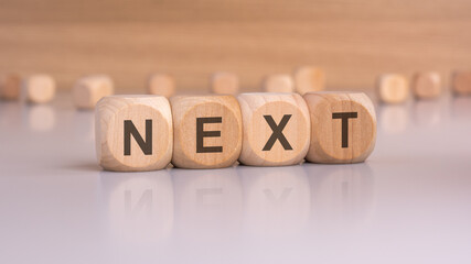 wooden blocks with text next, brown background