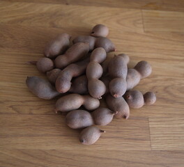 Tamarind, fruits of Tamarindus indica, raw tamarind fruits on wooden background