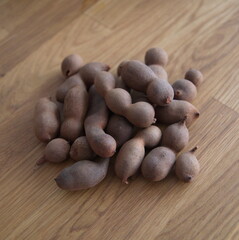Tamarind, fruits of Tamarindus indica, raw tamarind fruits on wooden background
