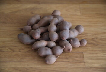 Tamarind, fruits of Tamarindus indica, raw tamarind fruits on wooden background
