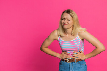 Sick ill young woman suffering from period cramps, painful stomach ache, holding belly, feeling...