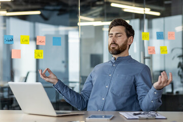 Businessman meditating at office desk for mindfulness and stress relief