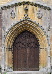 Obraz premium old gothic wooden door with an arched top and decorative carvings