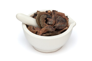 Close-up of Dry Organic Zebrawood or Kakda Singi (Pistacia integerrima), in white ceramic mortar and pestle, isolated on a white background.