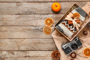 Composition with warm socks and photo camera on wooden background