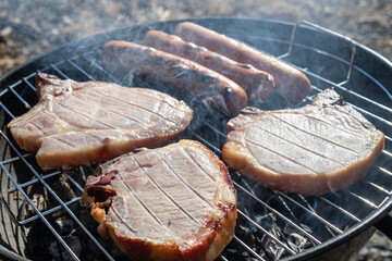 juicy delicious meat steaks and sausages fried on barbecue
