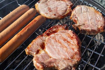 juicy delicious meat steaks and sausages fried on barbecue