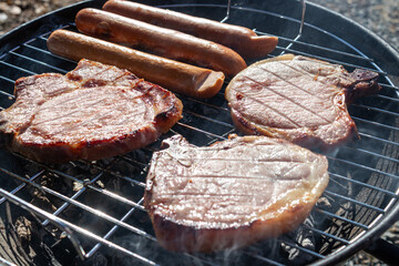 juicy delicious meat steaks and sausages fried on barbecue