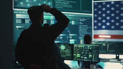 US military man supervising threat detection activity in high tech office, examining top secret data on big screen. Governmental soldiers managing hybrid war, cyber attack prevention. Camera A.