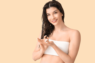 Beautiful young happy woman with hair mask on beige background