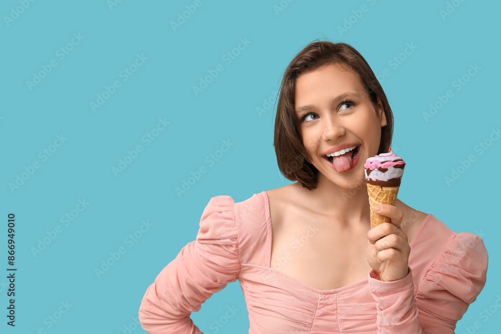 Poster beautiful young woman with sweet ice-cream in waffle cone showing tongue on blue background